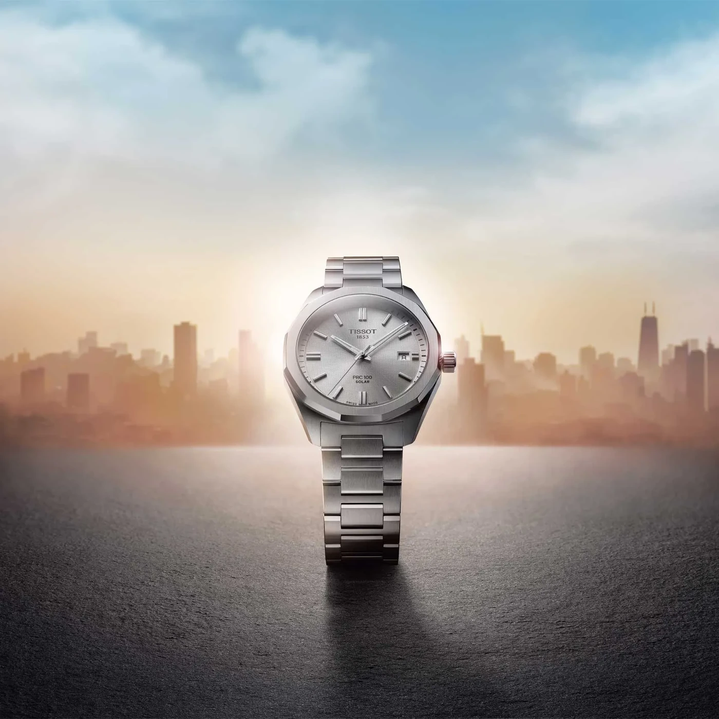 Reloj Tissot PRC 100 Solar sobre fondo de ciudad al atardecer